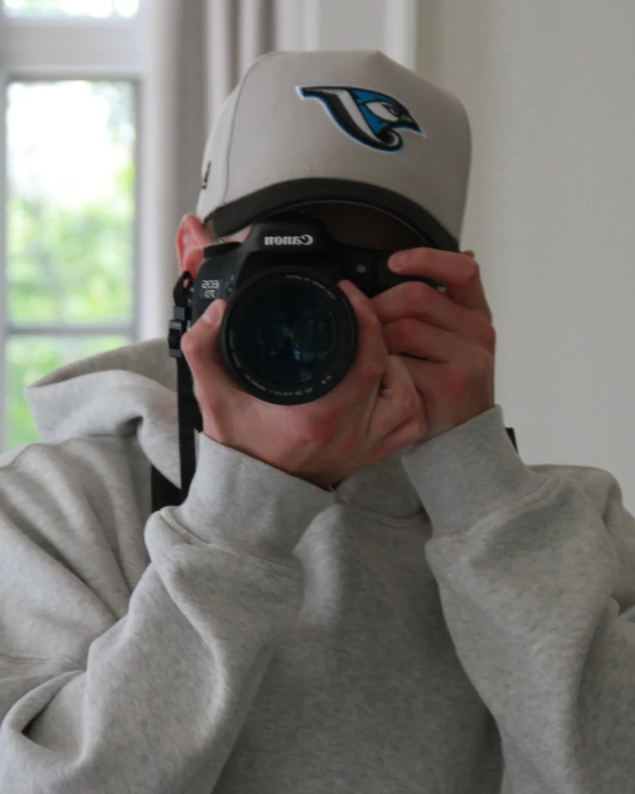 Zachary Black behind a Canon camera, lens pointed at the viewer